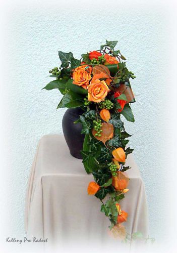 Klasická převislá svatební kytice tvořená z růží, břečťanu, doplněná plody Phisallisu a plody Ligustrum. 

